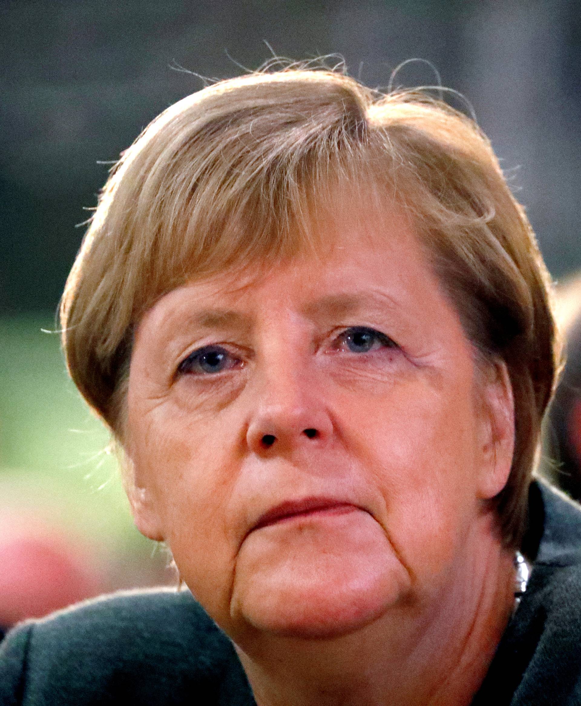 FILE PHOTO: German Chancellor Angela Merkel listens to Hesse State Prime Minister Volker Bouffier's speech during his election campaign rally in Ortenberg