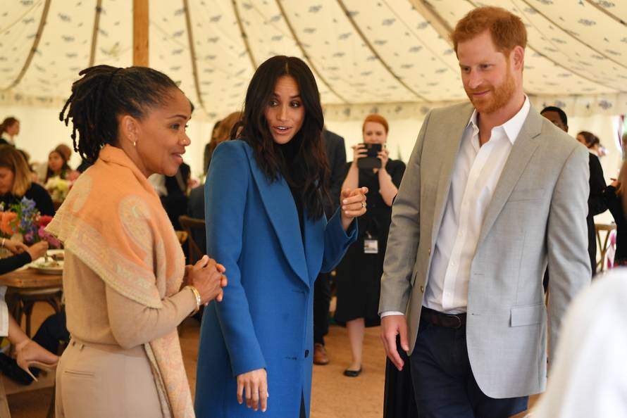 Meghan, Duchess of Sussex, her mother, Doria Ragland and Britain's Prince Harry take part in the launch of a cookbook with recipes from a group of women affected by the Grenfell Tower fire at Kensington Palace in London