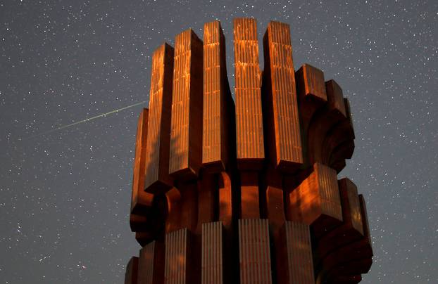 Meteor streaks across skies near the Monument to the Revolution in Prijedor