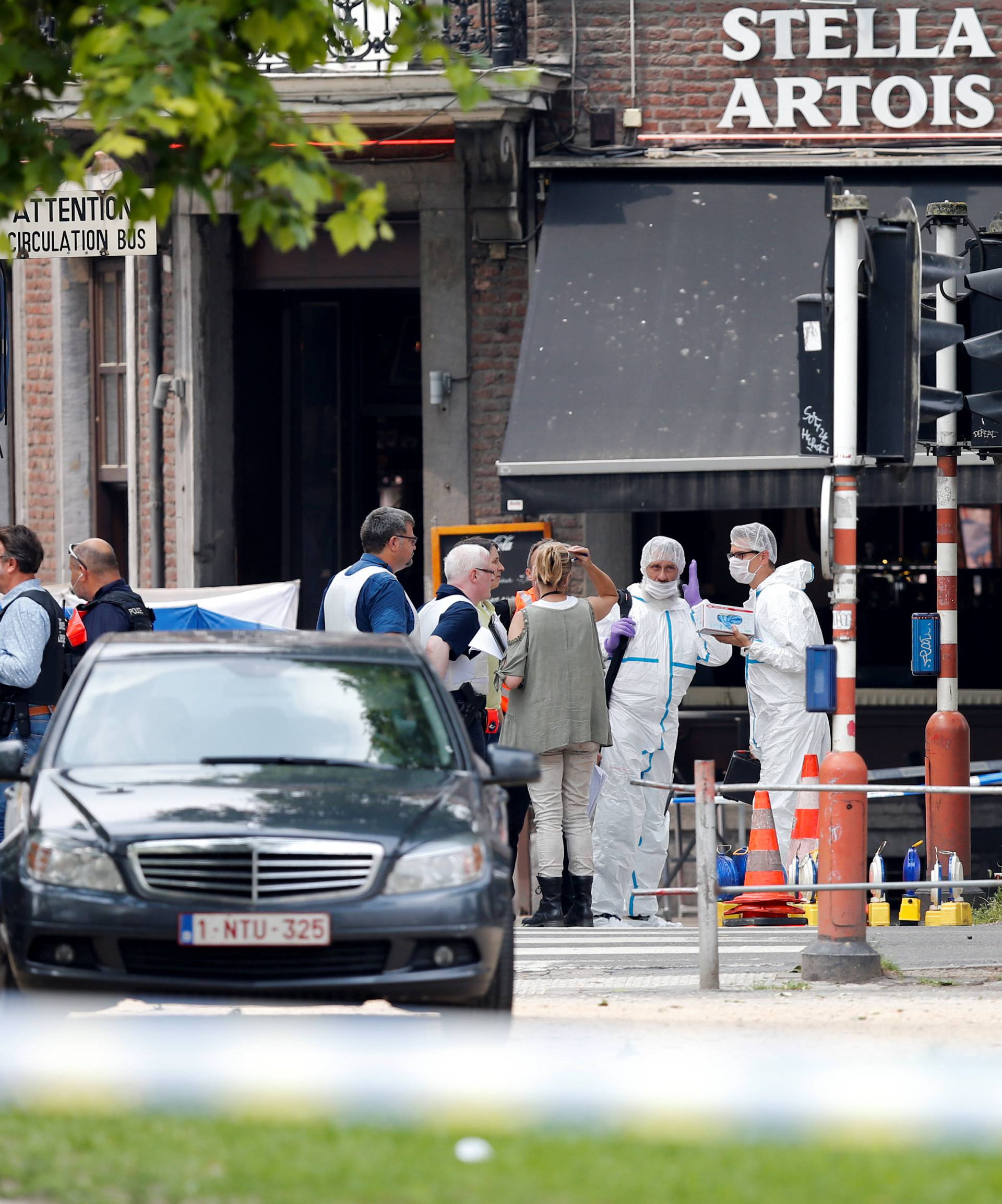 Police officers and forensics experts are seen on the scene of a shooting in Liege