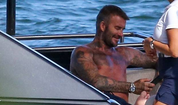 EXCLUSIVE: David Beckham looks happy as he shows off his tanned torso while spending yet another day on his yacht in Miami