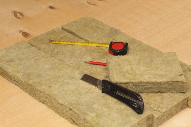 Cutted mineral wool, knife, pencil and  tape-measure