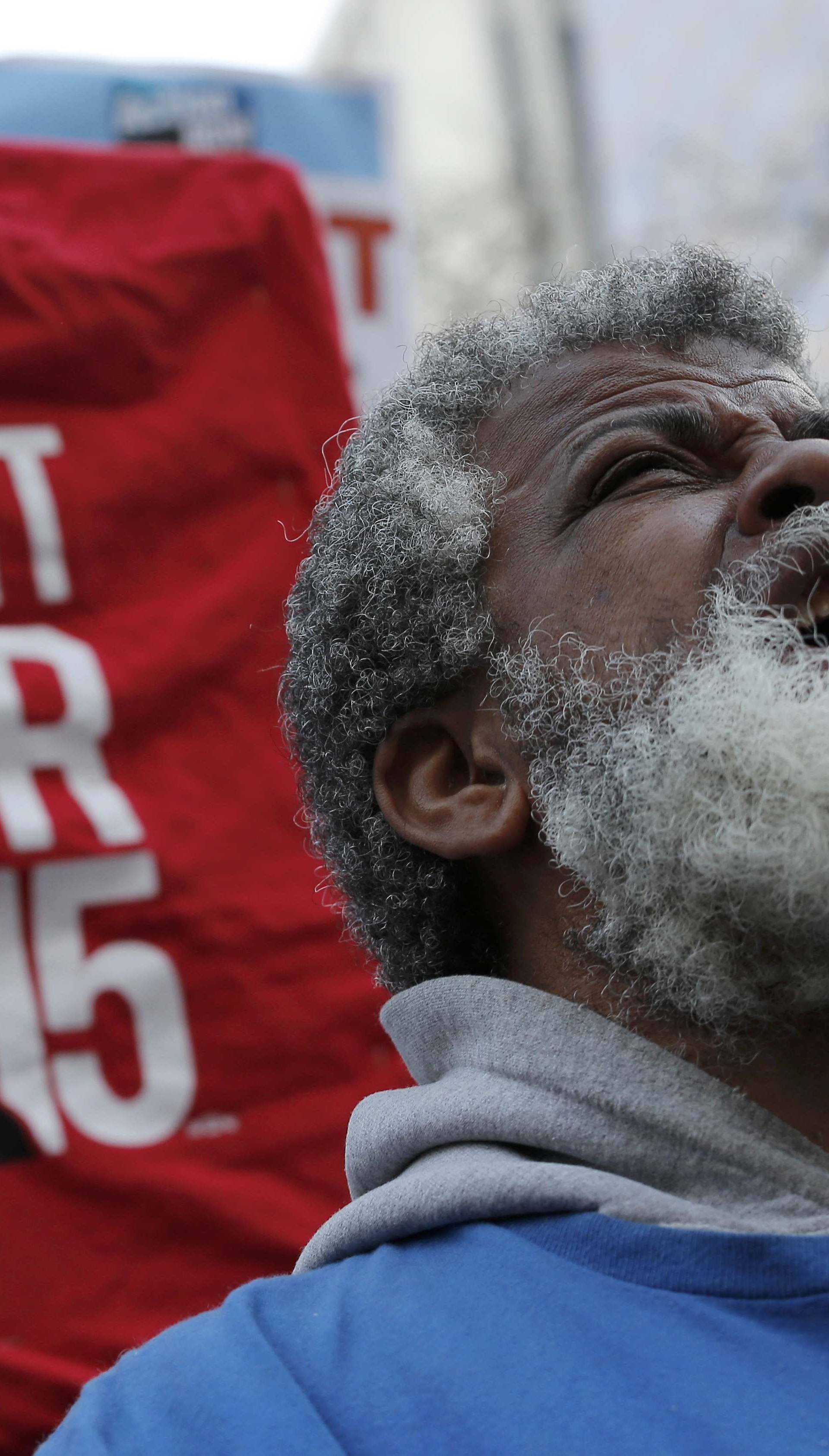 A demonstrator reacts as they gather on the sidewalk with placards during a protest for a $15-an-hour nationwide minimum wage in downtown Chicago