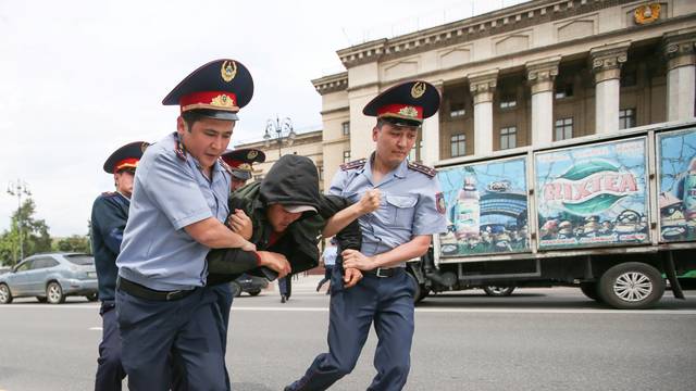 Police officers detain an opposition supporter during a protest against presidential election results, in Almaty