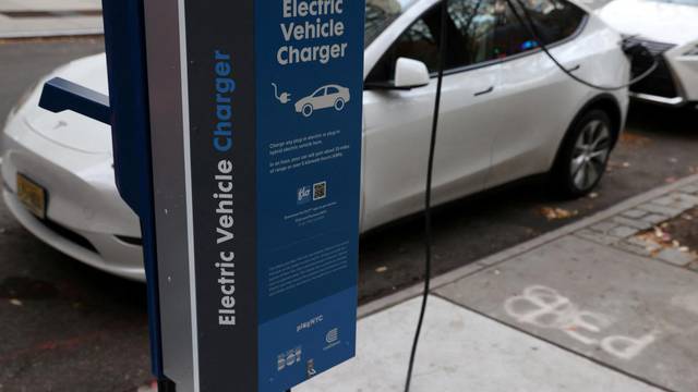 A electric vehicle charger is seen as a vehicle charges in Manhattan, New York