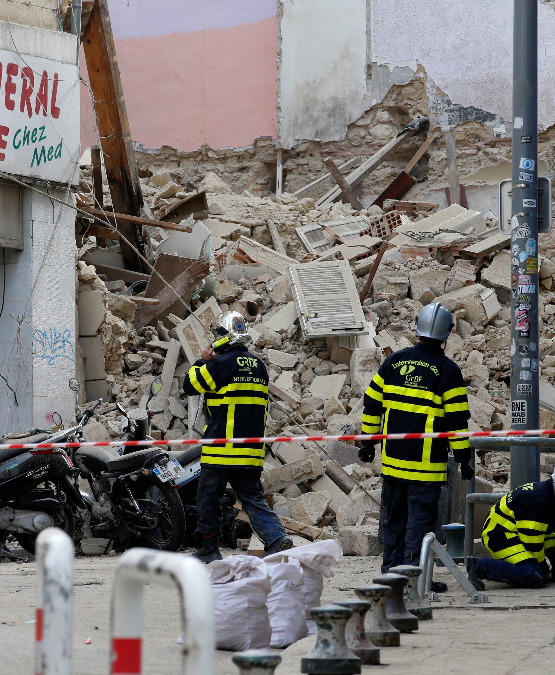 French rescue workers are seen near rubble after buildings collapsed in central Marseille