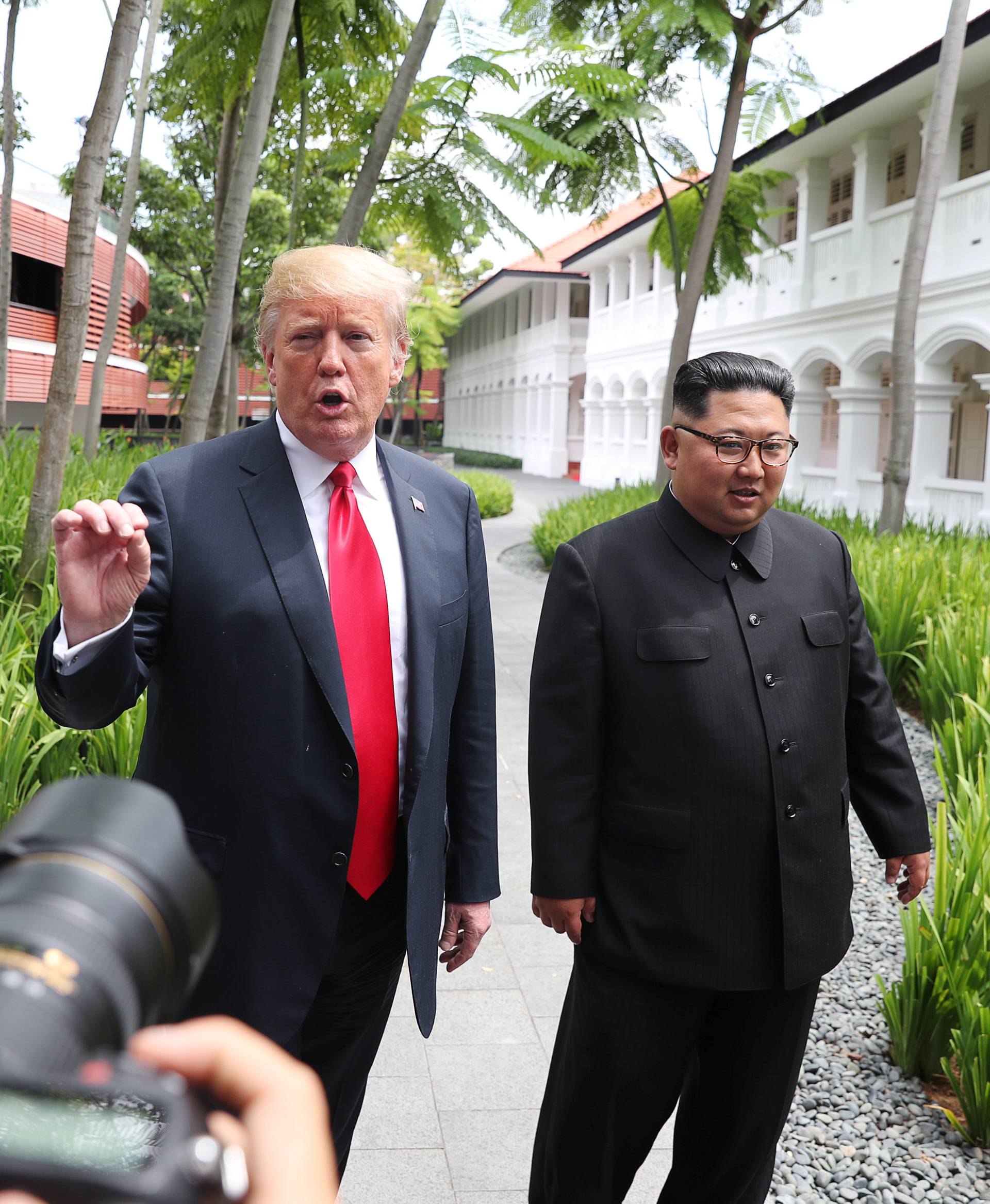 U.S. President Donald Trump and North Korean leader Kim Jong Un walk after lunch at the Capella Hotel on Sentosa island in Singapore