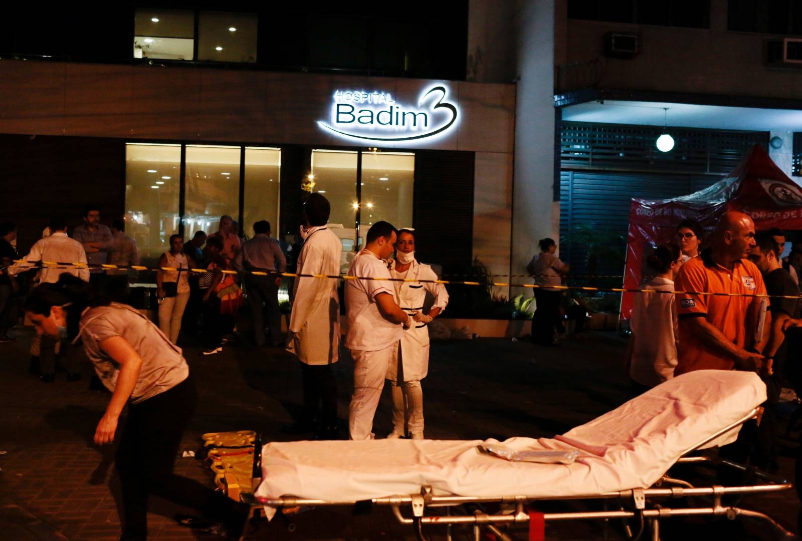 Employees are seen after a fire hit the Badim Hospital in Rio de Janeiro