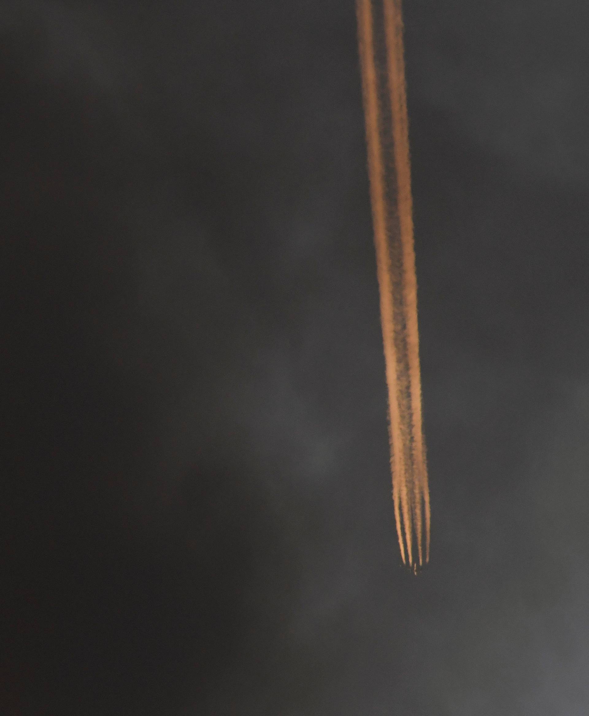 An airplane flies above as smoke billows as firefighters deal with a serious fire in a tower block at Latimer Road in West London