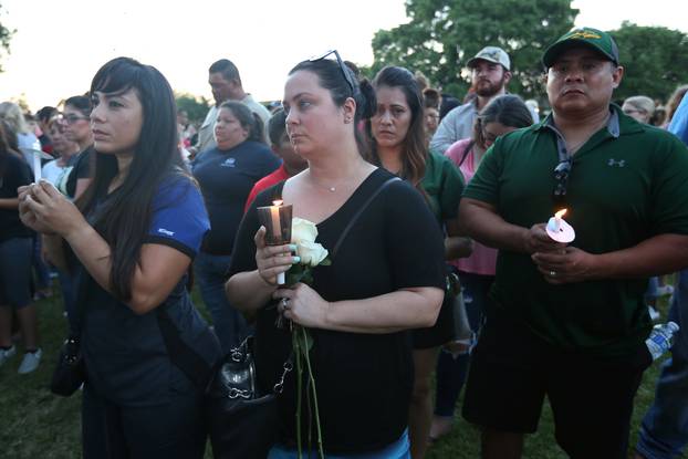 People gather with candles during a vigil held after a shooting left several people dead at Santa Fe High School in Santa Fe, Texas