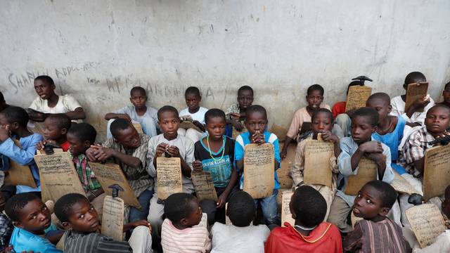 Boys hold slates with Arabic signs as they recite Koranic verses at Yahaya Ismail Quranic school in Kano.