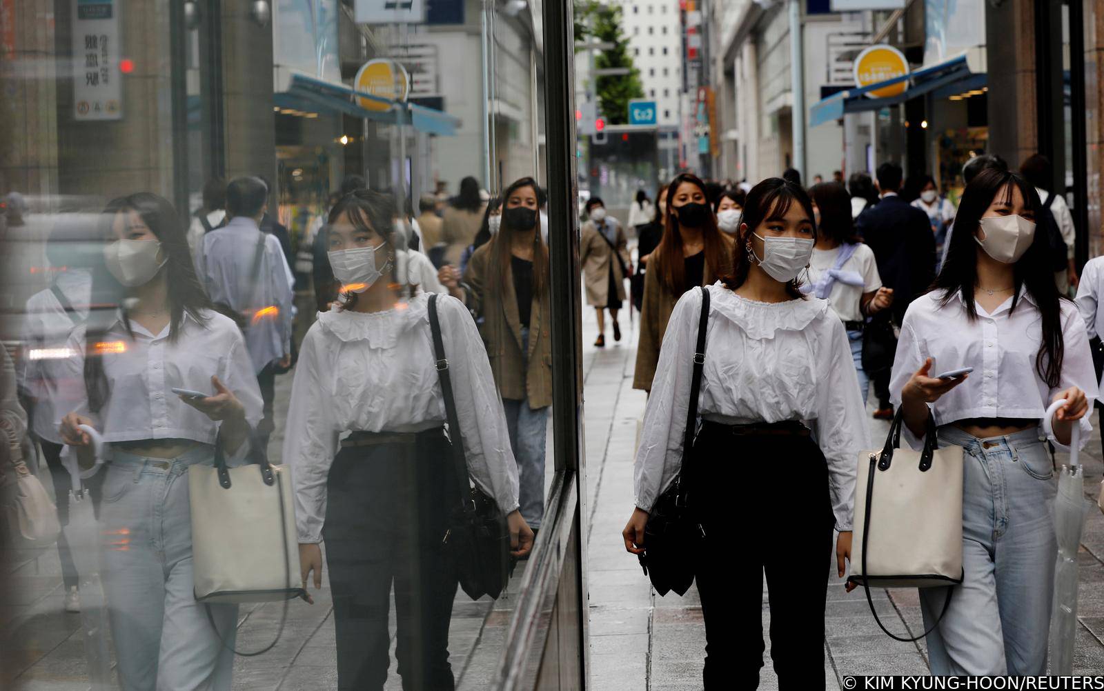 FILE PHOTO: People wearing protective masks in a shopping district in Tokyo,