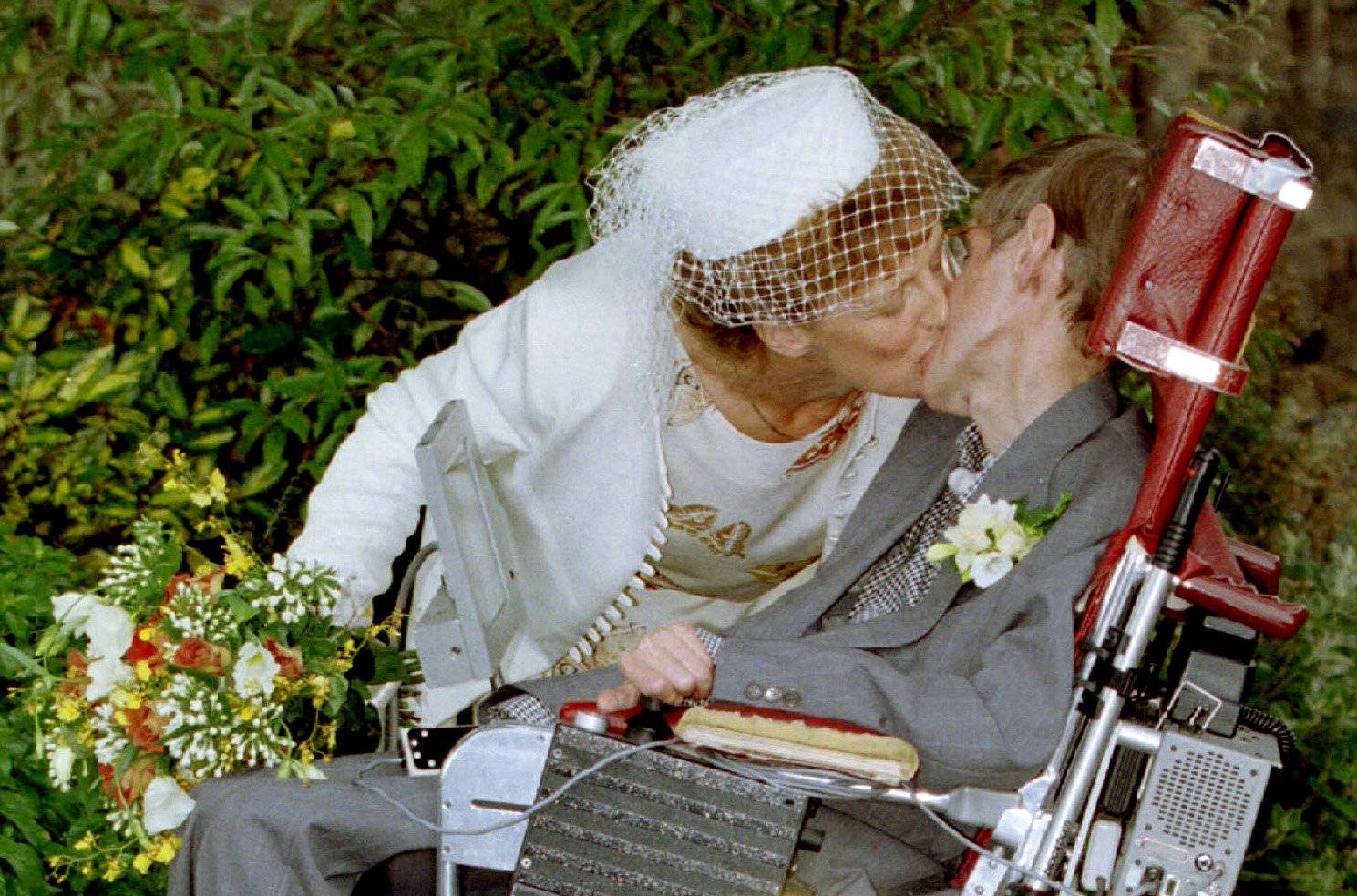 A kiss for scientist and theorist Stephen Hawking from his new bride Elaine Mason after their civil ..