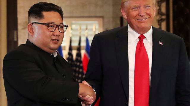 FILE PHOTO: President Donald Trump and North Korea's leader Kim Jong Un shake hands after signing documents during a summit in Singapore