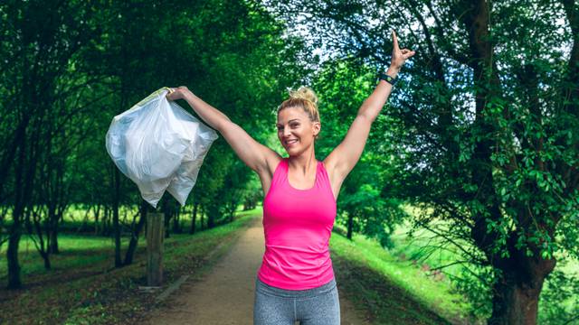 Happy,Girl,With,Arms,Up,Showing,The,Garbage,Bags,She