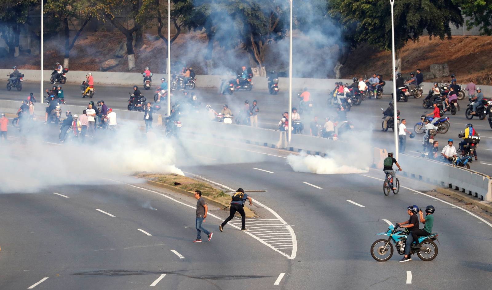 People react to tear gas near the Generalisimo Francisco de Miranda Airbase in Caracas