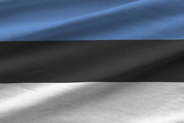 Estonia flag with big folds waving close up under the studio light indoors. The official symbols and colors in banner