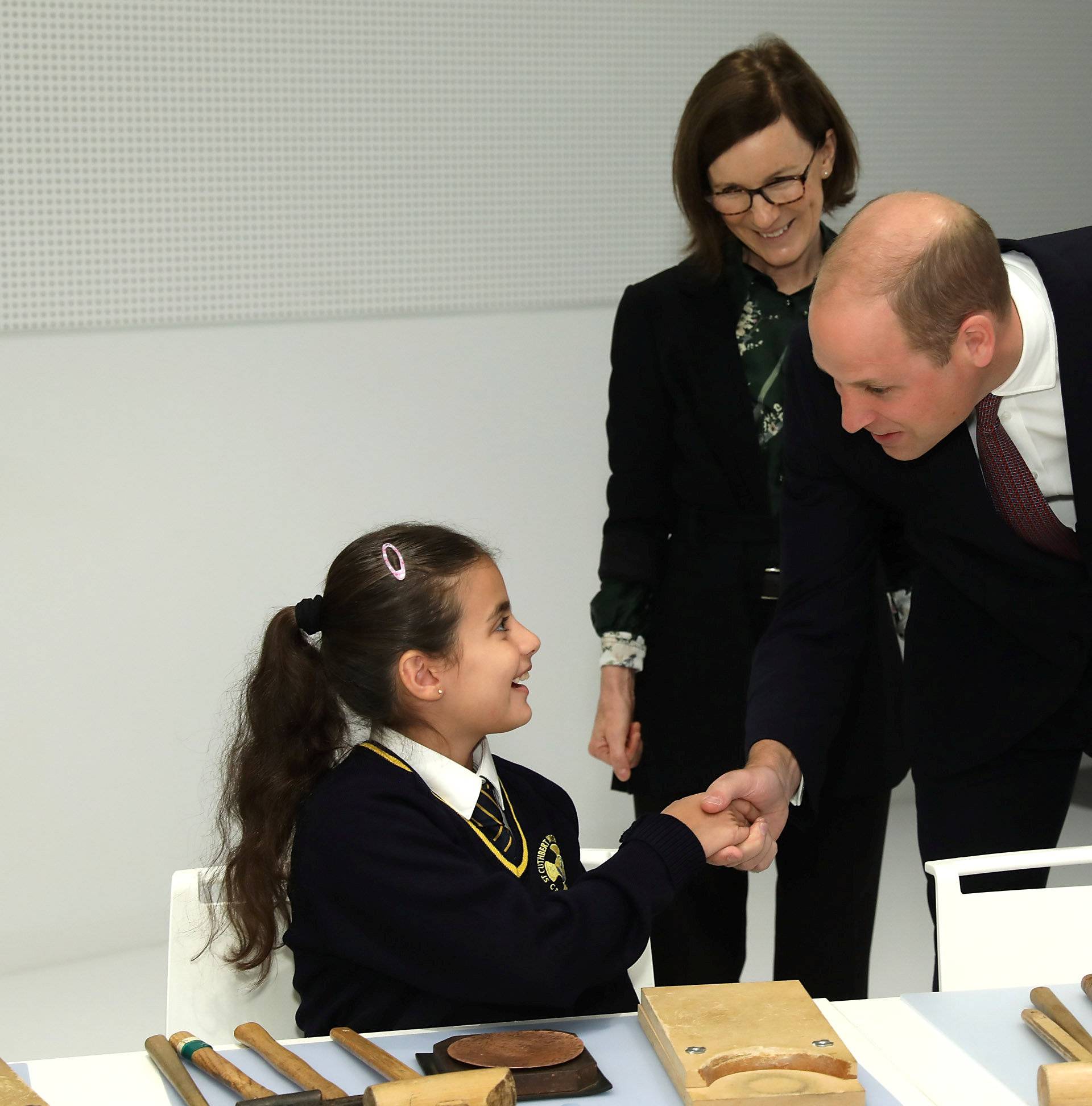 Britain's Prince William joins local school children from St Cuthbert with St Matthias CE Primary School at a copper beating workshop during the official opening of Japan House in London