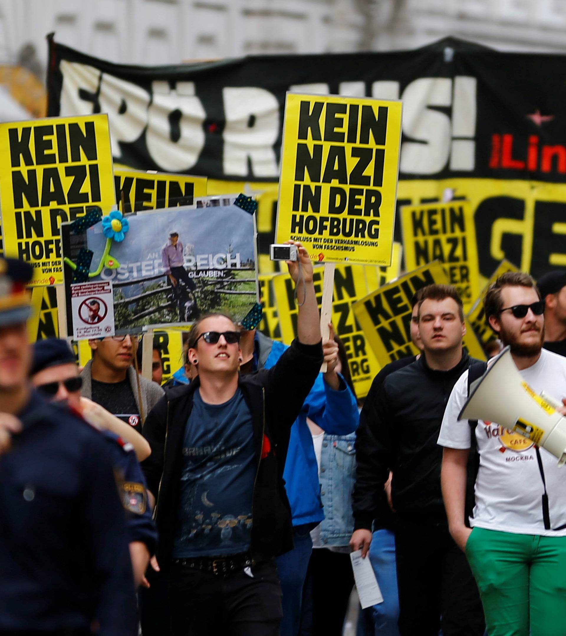 Protestors hold signs during a demonstration against FPOe presidential candidate Hofer in Vienna