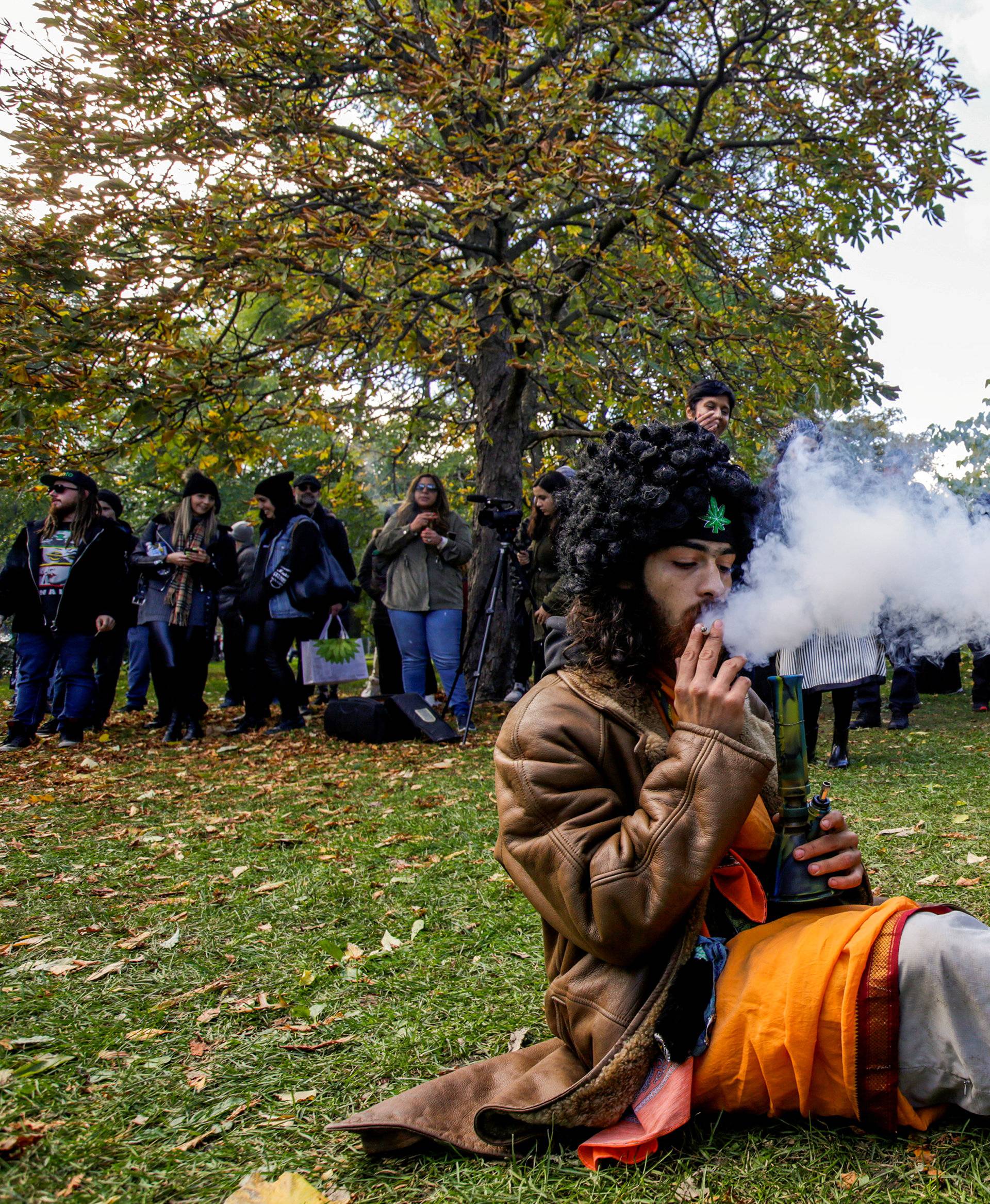 A man smokes a bong and a cigarette on the day Canada legalizes recreational marijuana at Trinity Bellwoods Park