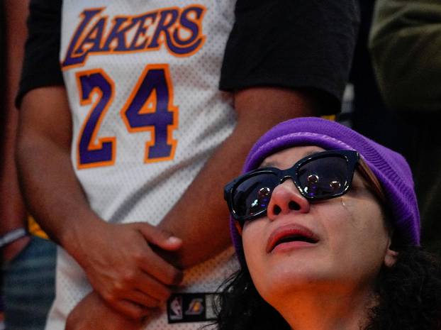 A mourner reacts while gathering with others in Microsoft Square near the Staples Center to pay respects to Kobe Bryant after a helicopter crash killed the retired basketball star, in Los Angeles