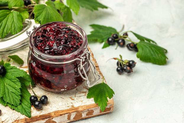 black currant jam curd, custard or jam in jar. place for text, top view