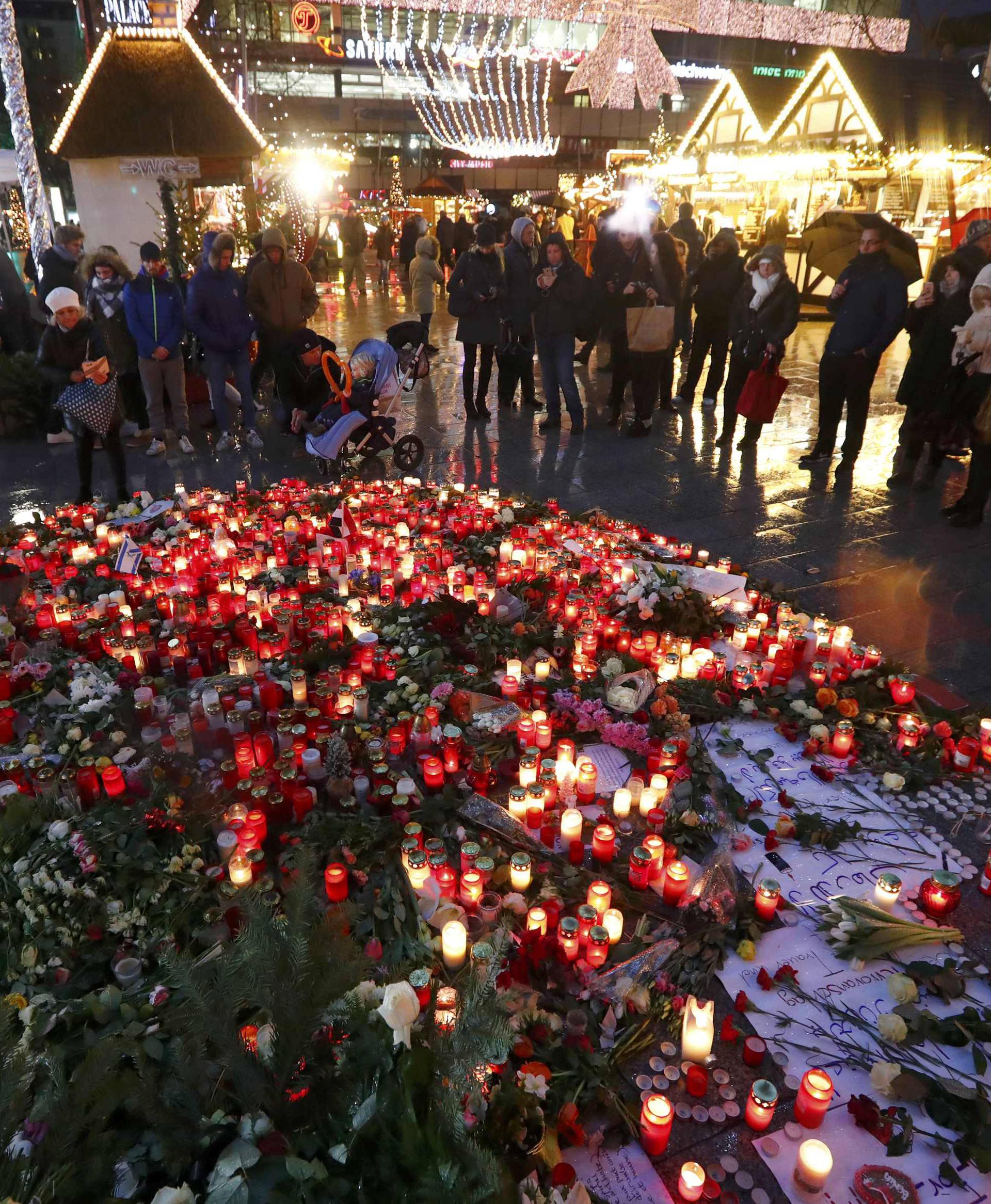 Flowers and candles are placed at the Christmas market at Breitscheid square in Berlin