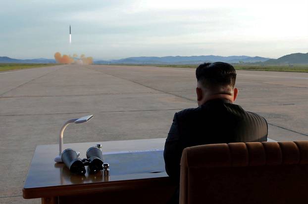 FILE PHOTO: North Korean leader Kim Jong Un watches the launch of a Hwasong-12 missile in this undated photo released by North Korea