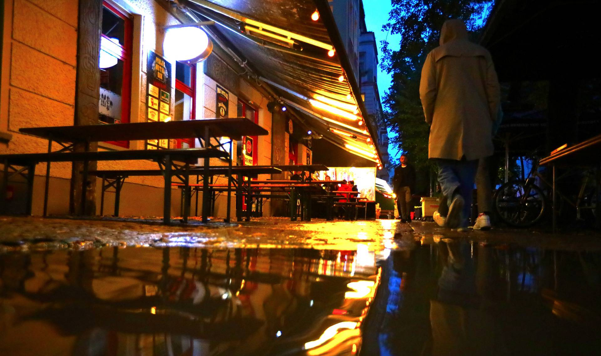 A woman passes empty tables before the late-night curfew due to restrictions against the spread of the coronavirus disease (COVID-19)in Berlin