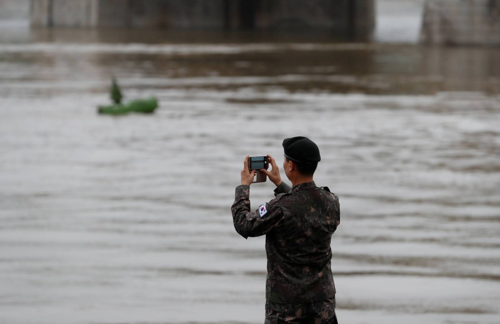 Military official from the South Korean Embassy takes photos at the Danube river bank in Budapest