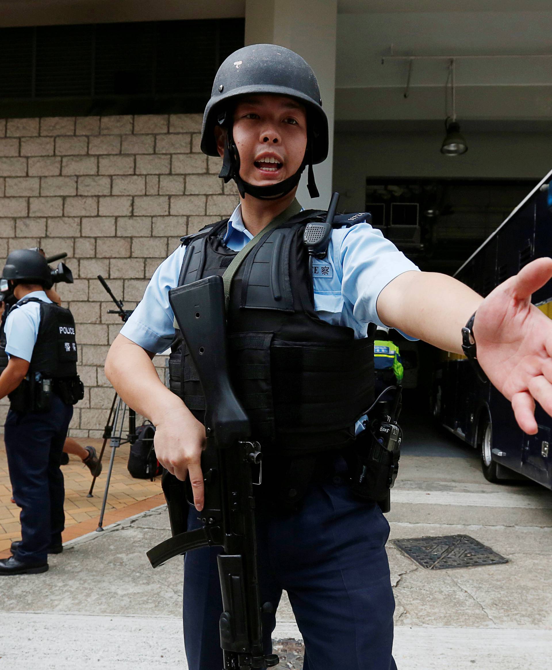 Armed policemen guard the entrance as a prison car carrying British former banker Rurik Jutting enters High Court in Hong Kong
