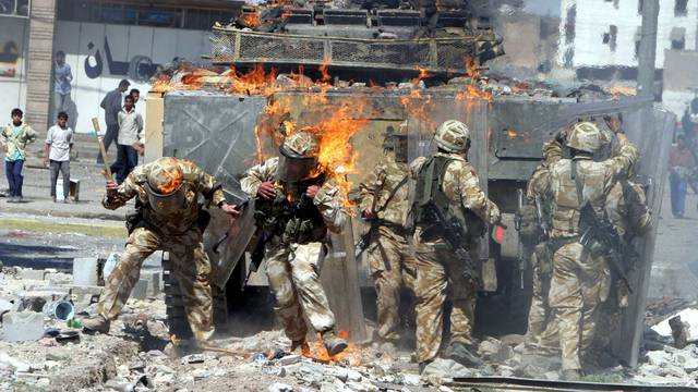 File photo of British Army troops covered in flames from a petrol bomb thrown during a violent protest by job seekers in Basra