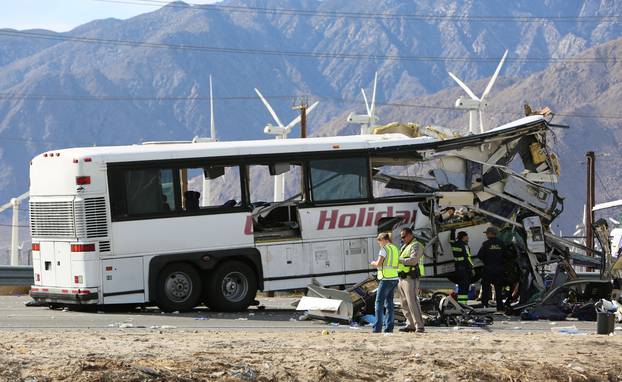 Investigators confer at the scene of a mass casualty bus crash on the westbound Interstate 10 freeway near Palm Springs, California