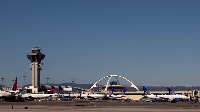 United Airlines planes are seen in the foreground of the Los Angeles International Airport and its air traffic control tower