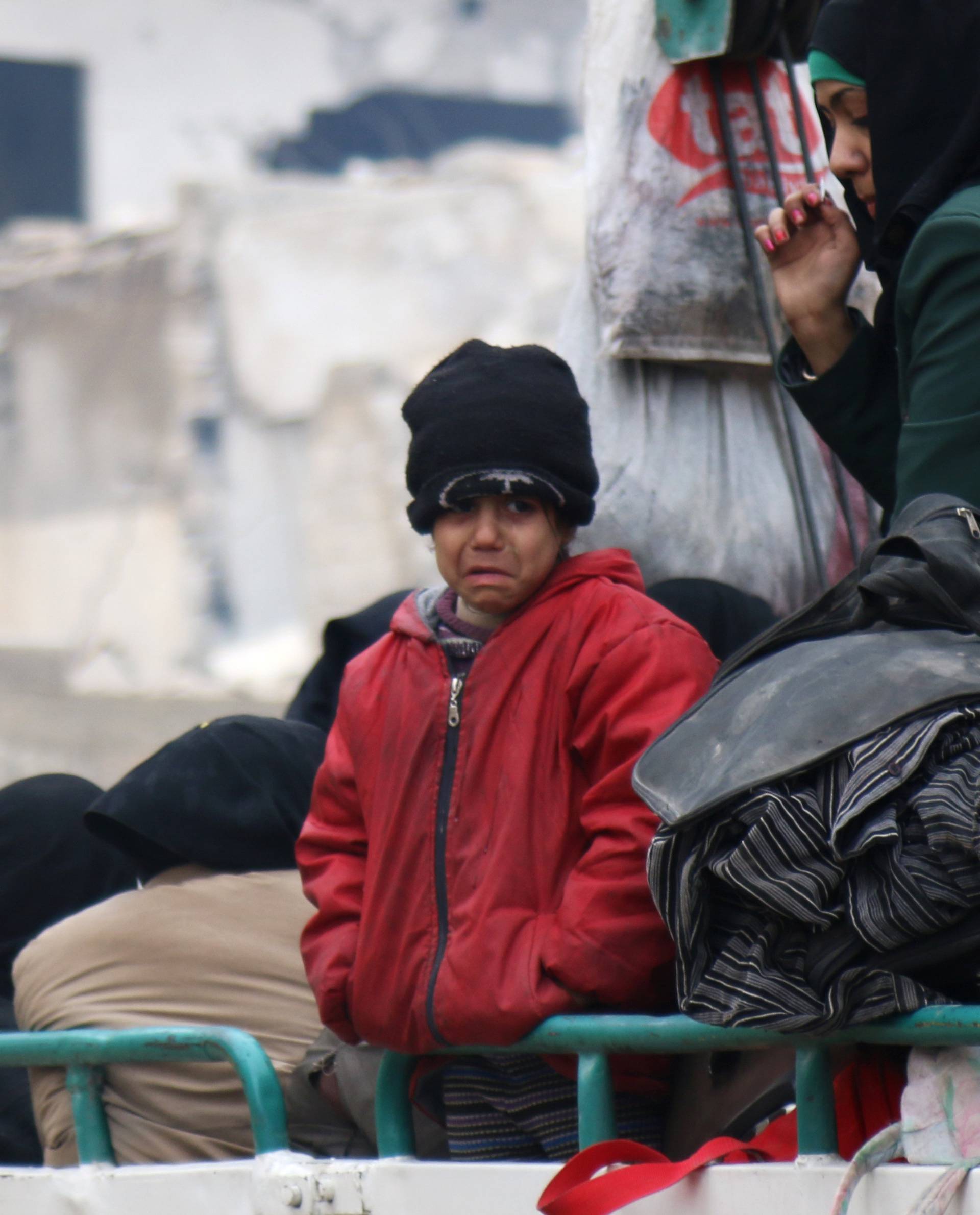 A child reacts while waiting with others to be evacuated from a rebel-held sector of eastern Aleppo