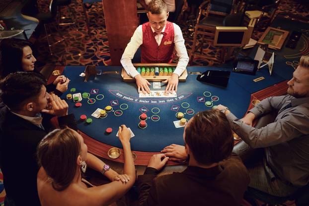 Group,Of,People,Gambling,Sitting,At,A,Table,In,A