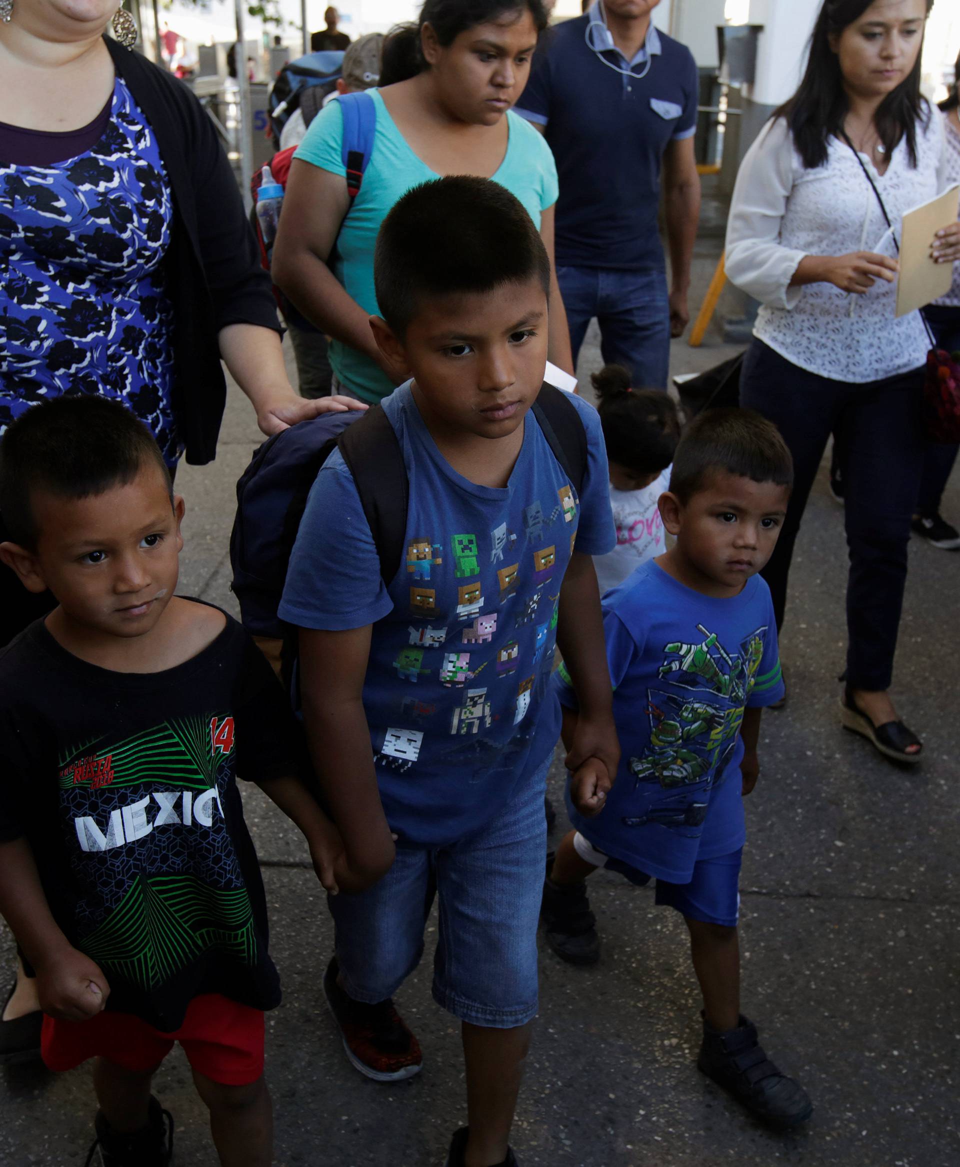 Migrant families from Mexico, fleeing from violence, walk toward the United States to apply for asylum at Paso del Norte international border crossing bridge in Ciudad Juarez