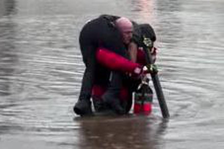 Povodeň v New Jersey: Policista nese na ramenou muže uvízlého v autě