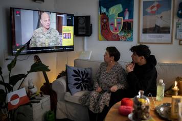 Liv Aurora Jensen with her son Inuk Stender Jensen watch news about meeting between top U.S. officials and the foreign ministers of Denmark and Greenland, in their home in Nuuk