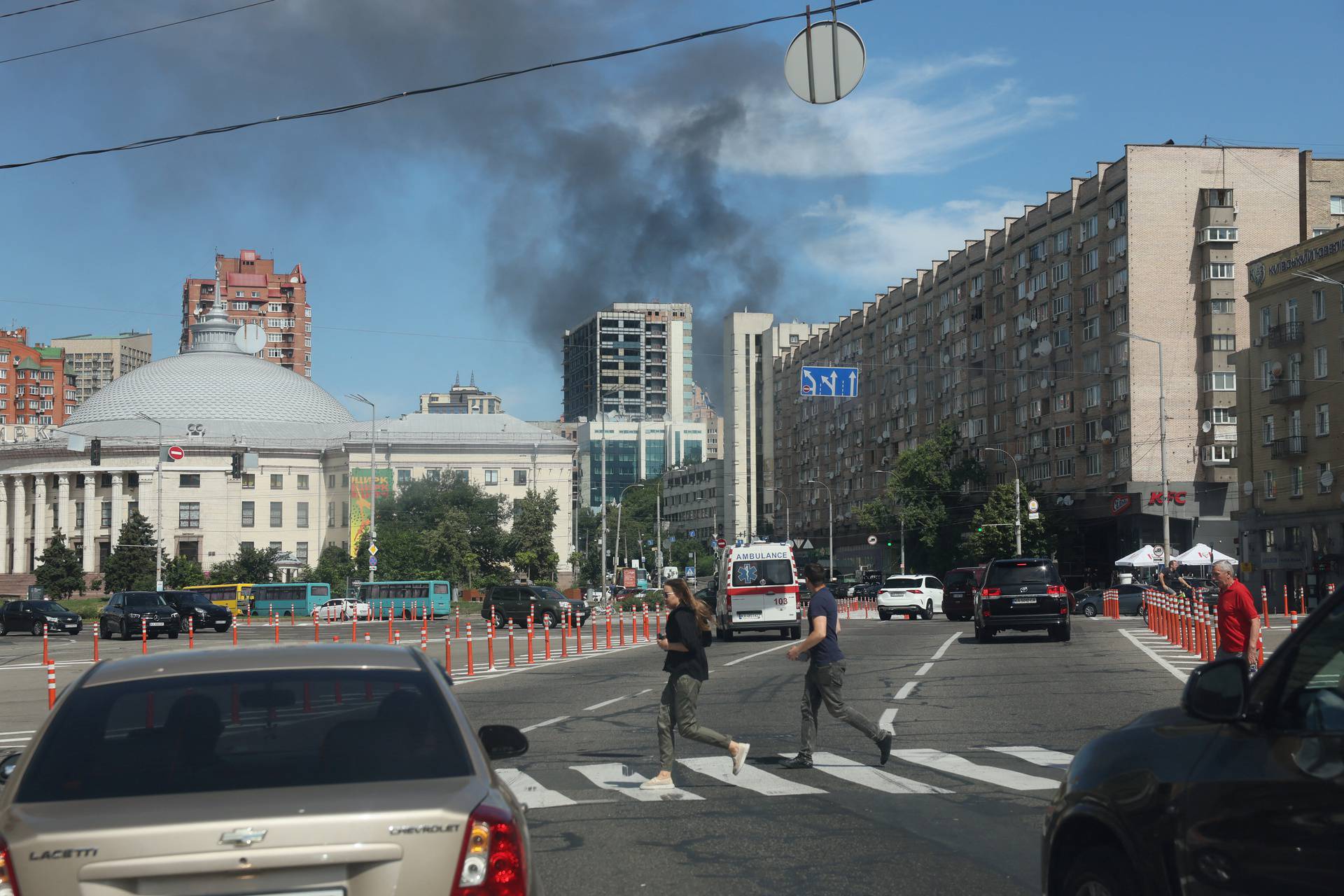 Smoke rises as people run, following Russian missile strikes, in Kyiv