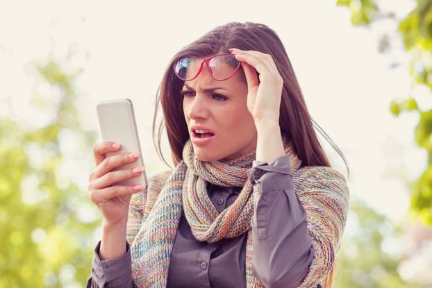 Annoyed,Upset,Woman,In,Glasses,Looking,At,Her,Smart,Phone
