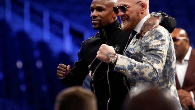 Undefeated boxer Floyd Mayweather Jr. (L) of the U.S. and UFC lightweight champion Conor McGregor of Ireland pose during post-fight news conference at T-Mobile Arena in Las Vegas