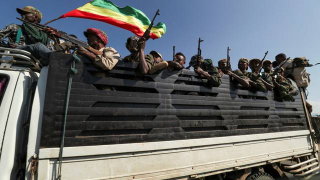 FILE PHOTO: Members of Amhara region militias ride on their truck as they head to face the Tigray People's Liberation Front in Sanja