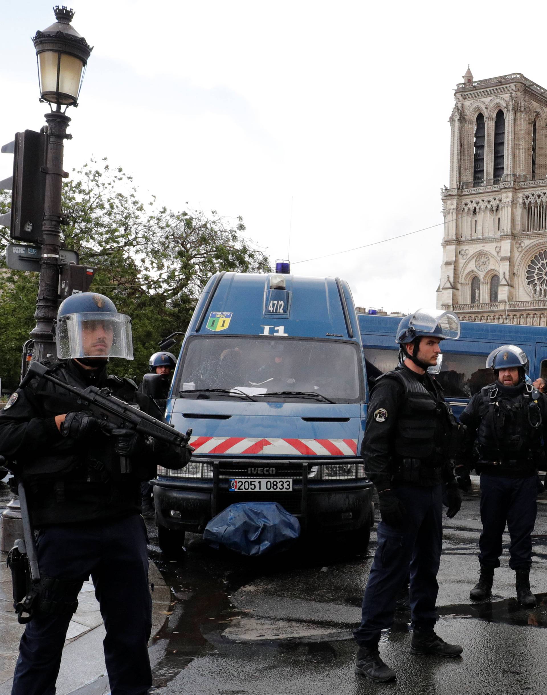 French police stand at the scene of a shooting incident near the Notre Dame Cathedral in Paris