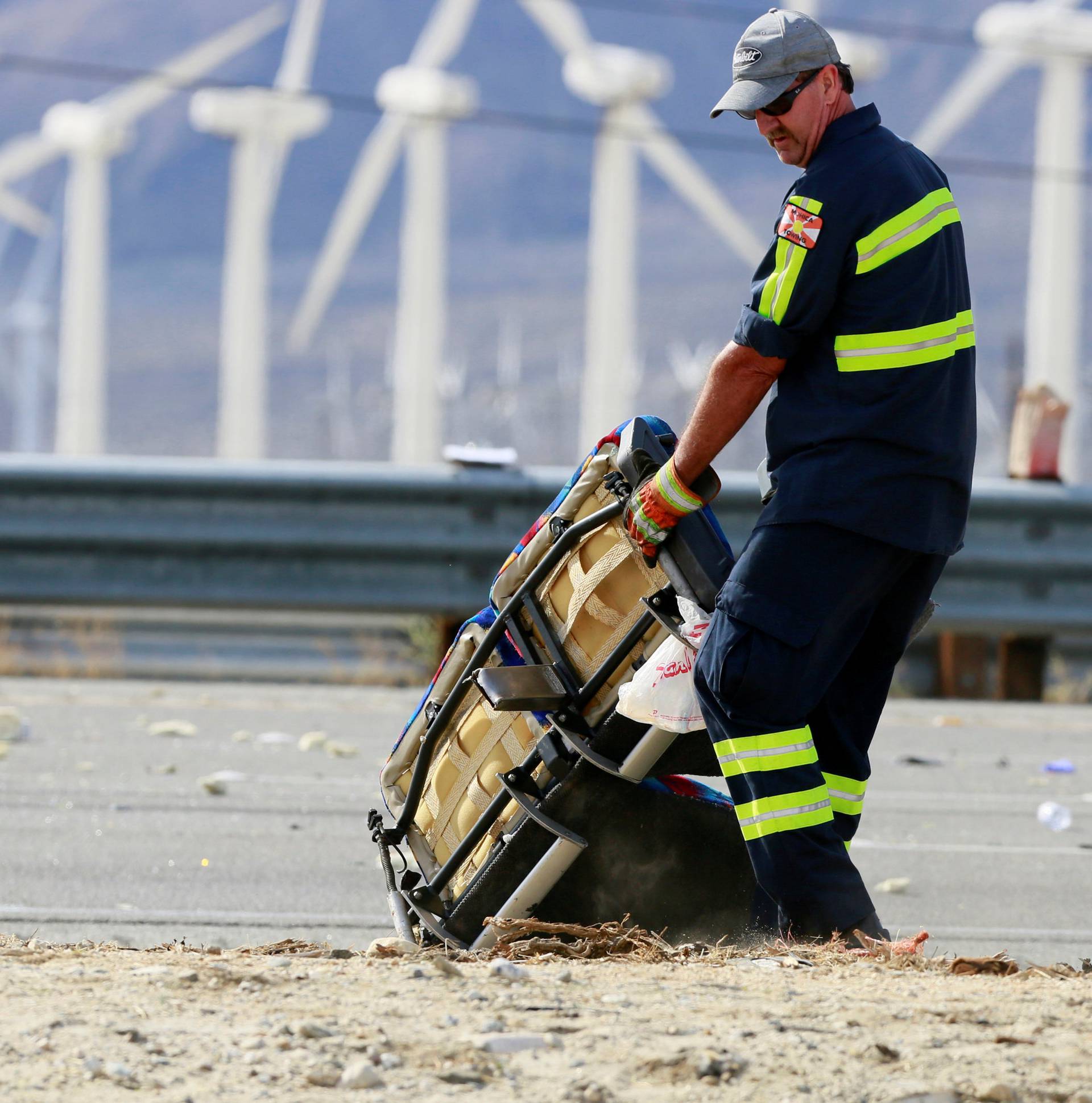 A tow truck driver helps clear debris at the scene of a mass fatality bus crash on the westbound Interstate 10 freeway near Palm Springs