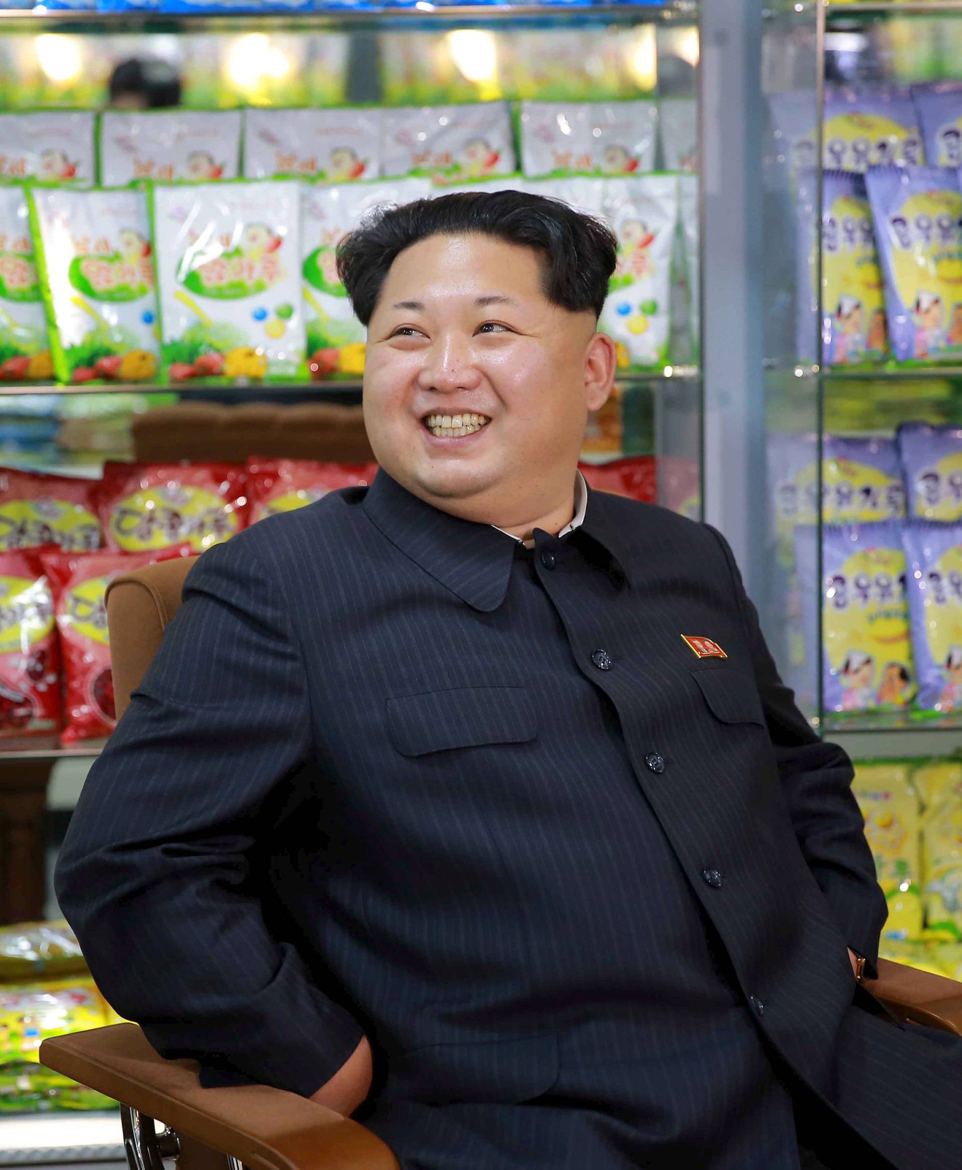 FILE PHOTO: KCNA picture shows North Korean leader Kim Jong Un smiling while sitting during a visit to inspect the Pyongyang Children's Foodstuff Factory