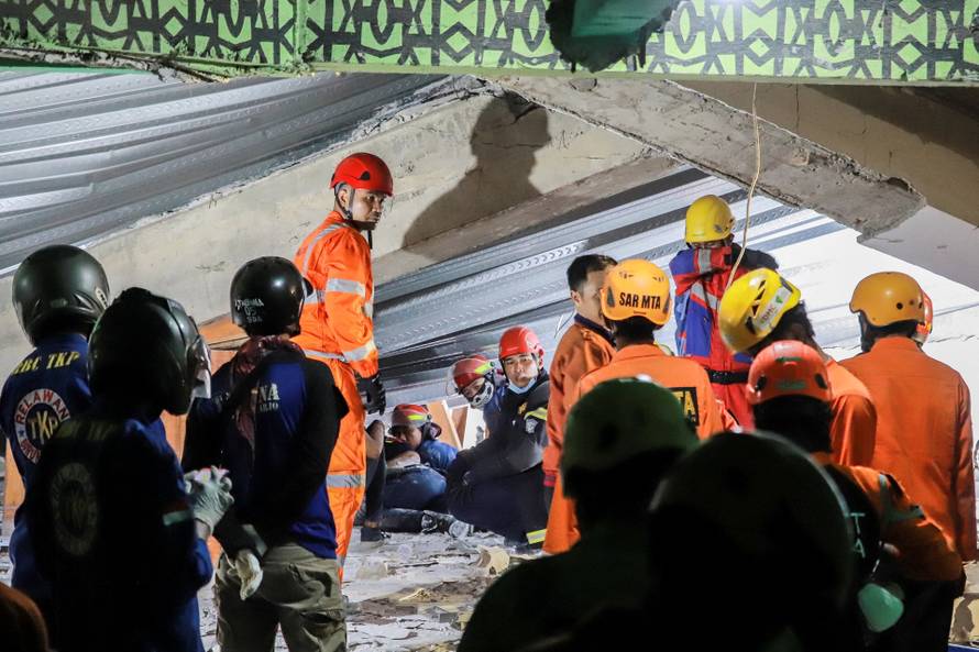 Search and rescue officers search for victims in the rubble of a collapsed building at an Islamic boarding school in Sidoarjo