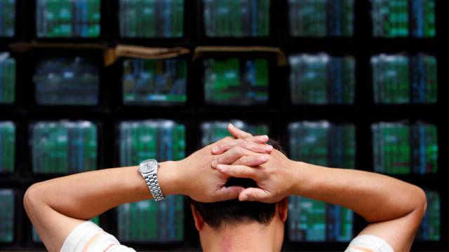 FILE PHOTO: A man looks at stock market monitors in Taiwan
