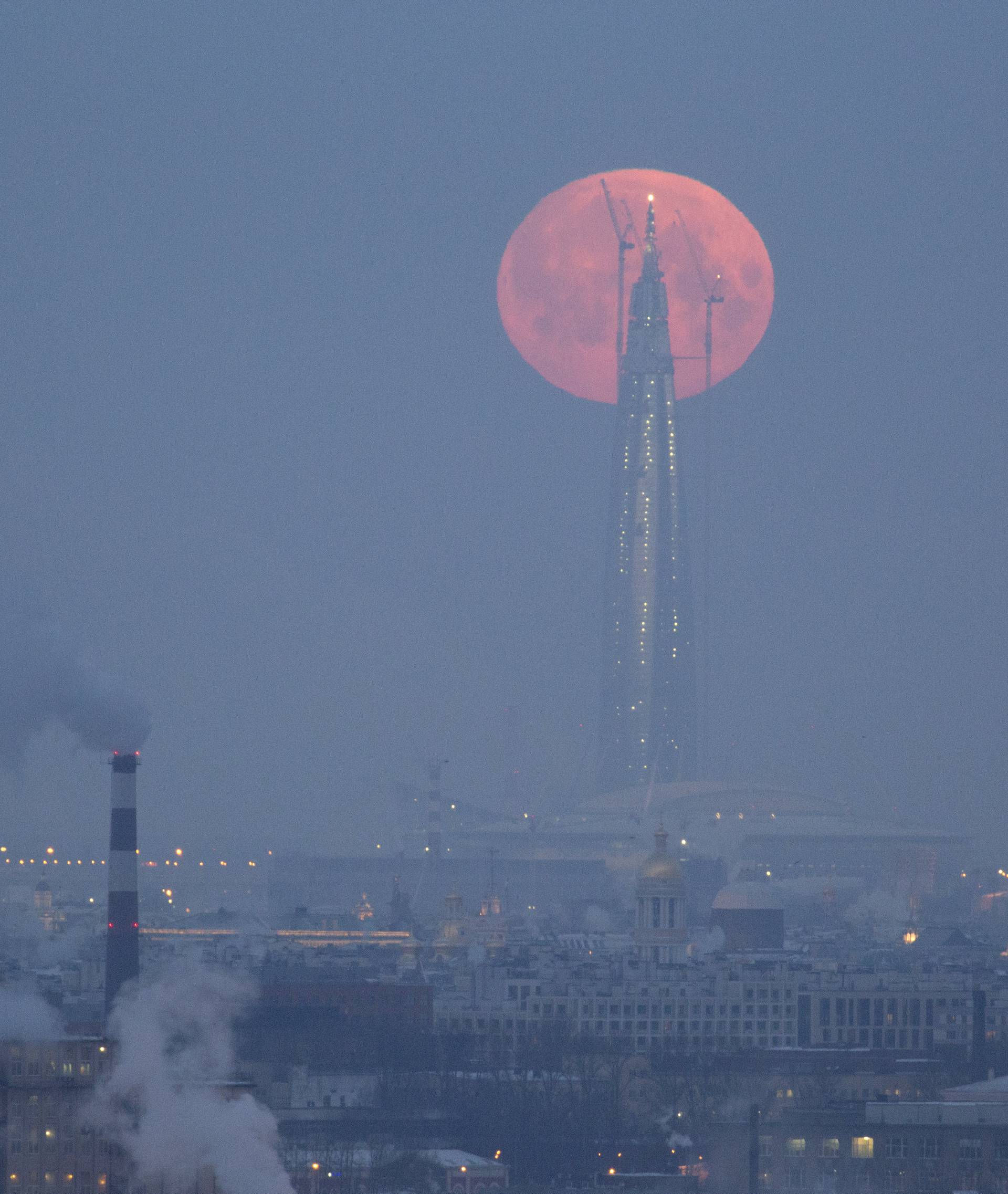 A full moon is seen behind the business tower Lakhta Centre in St. Petersburg