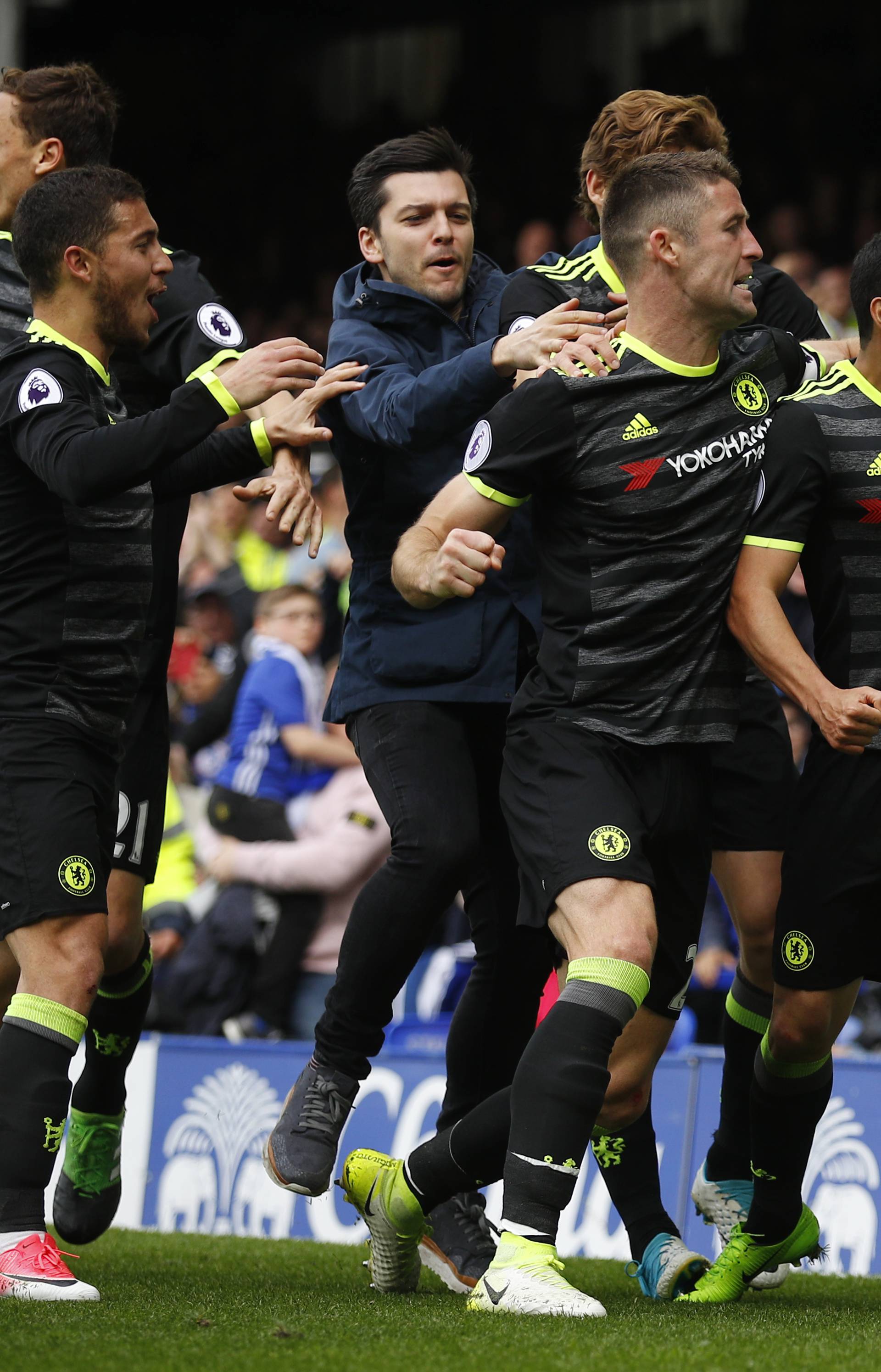 Chelsea's Pedro celebrates scoring their first goal with teammates as a fan invades the pitch